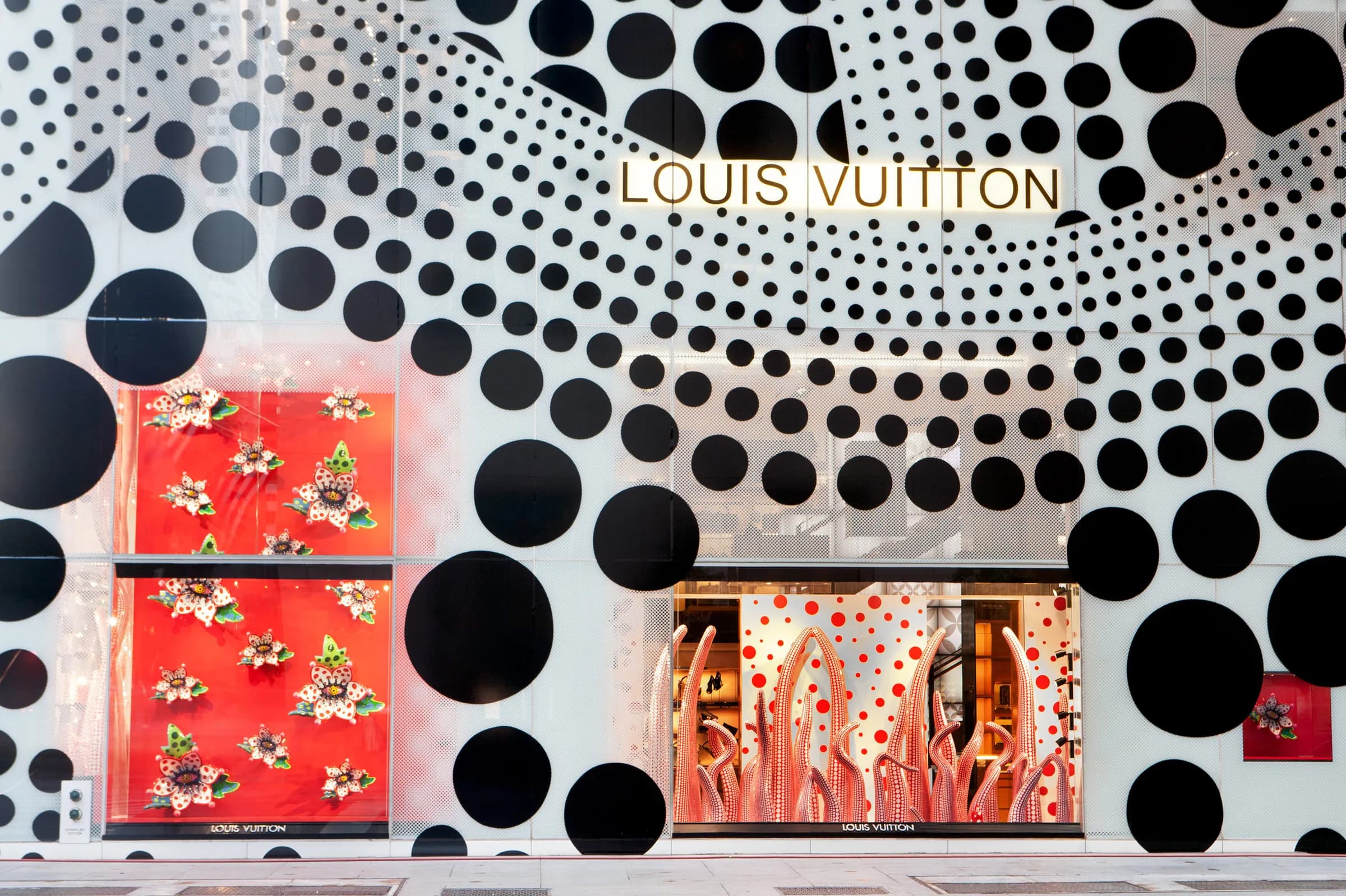 Louis Vuitton facade covered in large-format polka-dot graphics framing red window displays