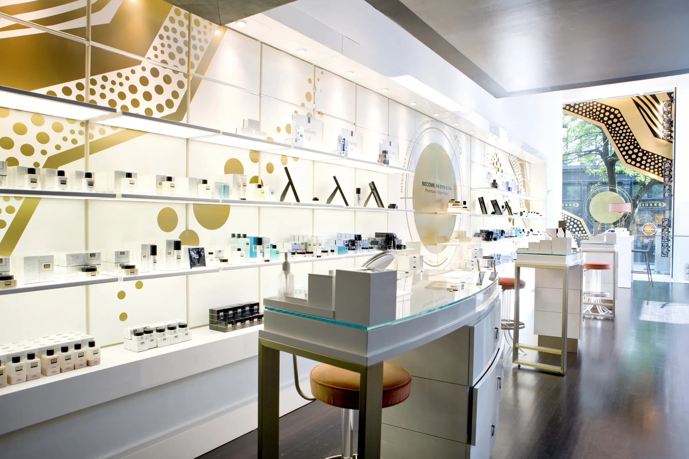 Bright Erno Laszlo boutique interior with white shelving, gold graphic walls and custom counters