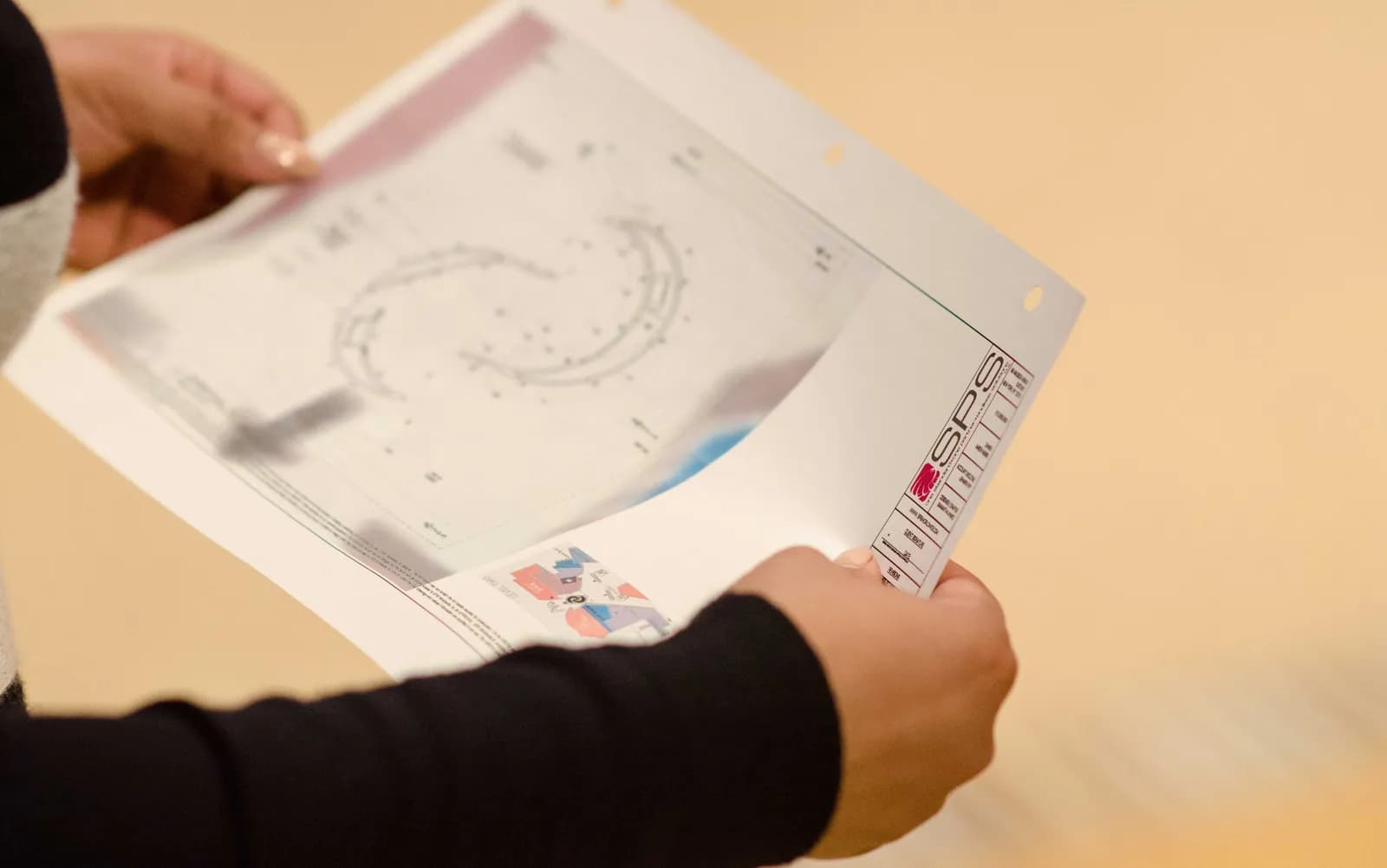 Hands holding printed installation plans during a Bulgari Serpenti build