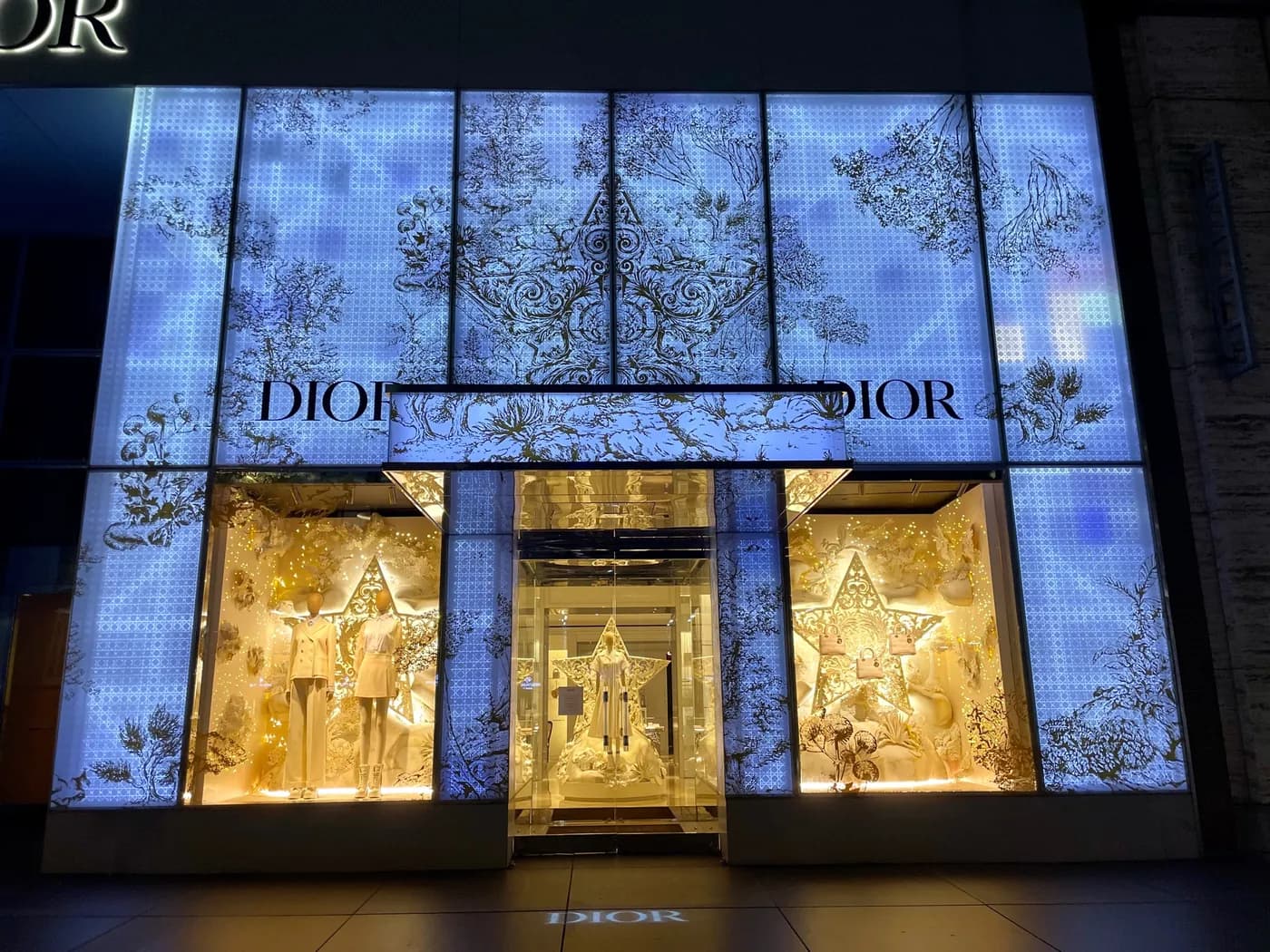 Dior 57th Street facade glowing with backlit botanical panels at night