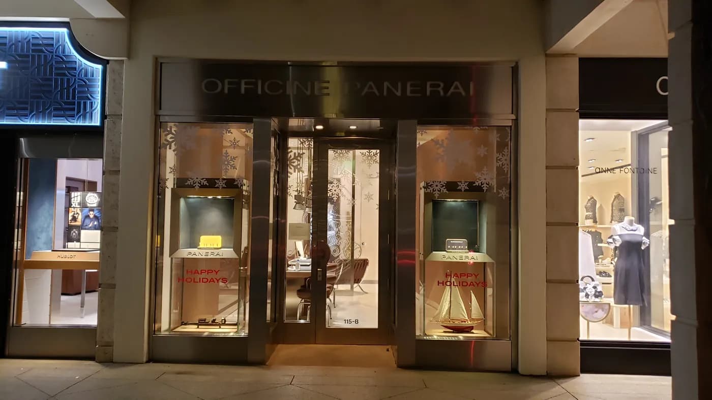 Officine Panerai storefront at night with snowflake holiday window graphics