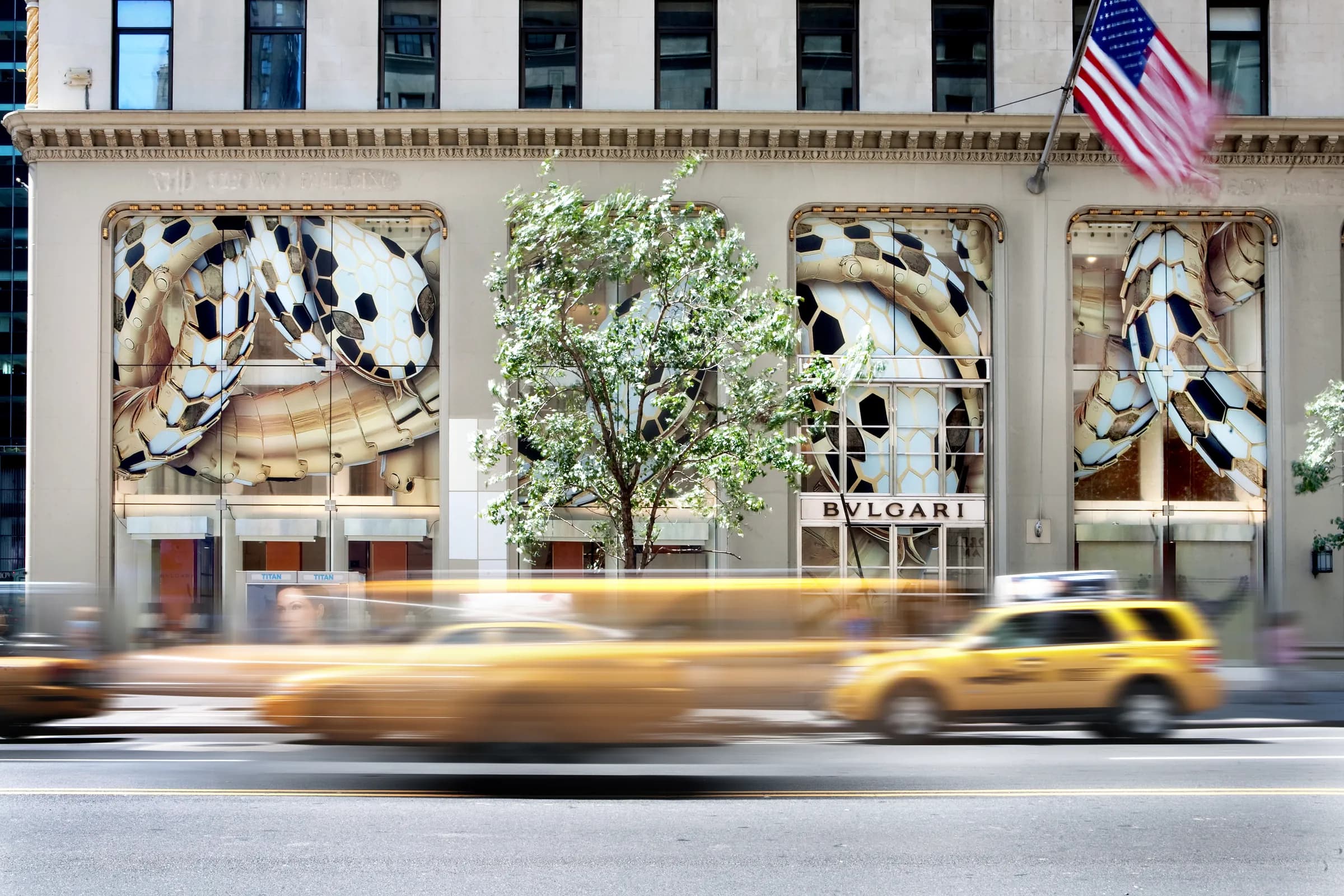 Bulgari flagship facade wrapped in oversized Serpenti scale graphics, with yellow taxis streaking past