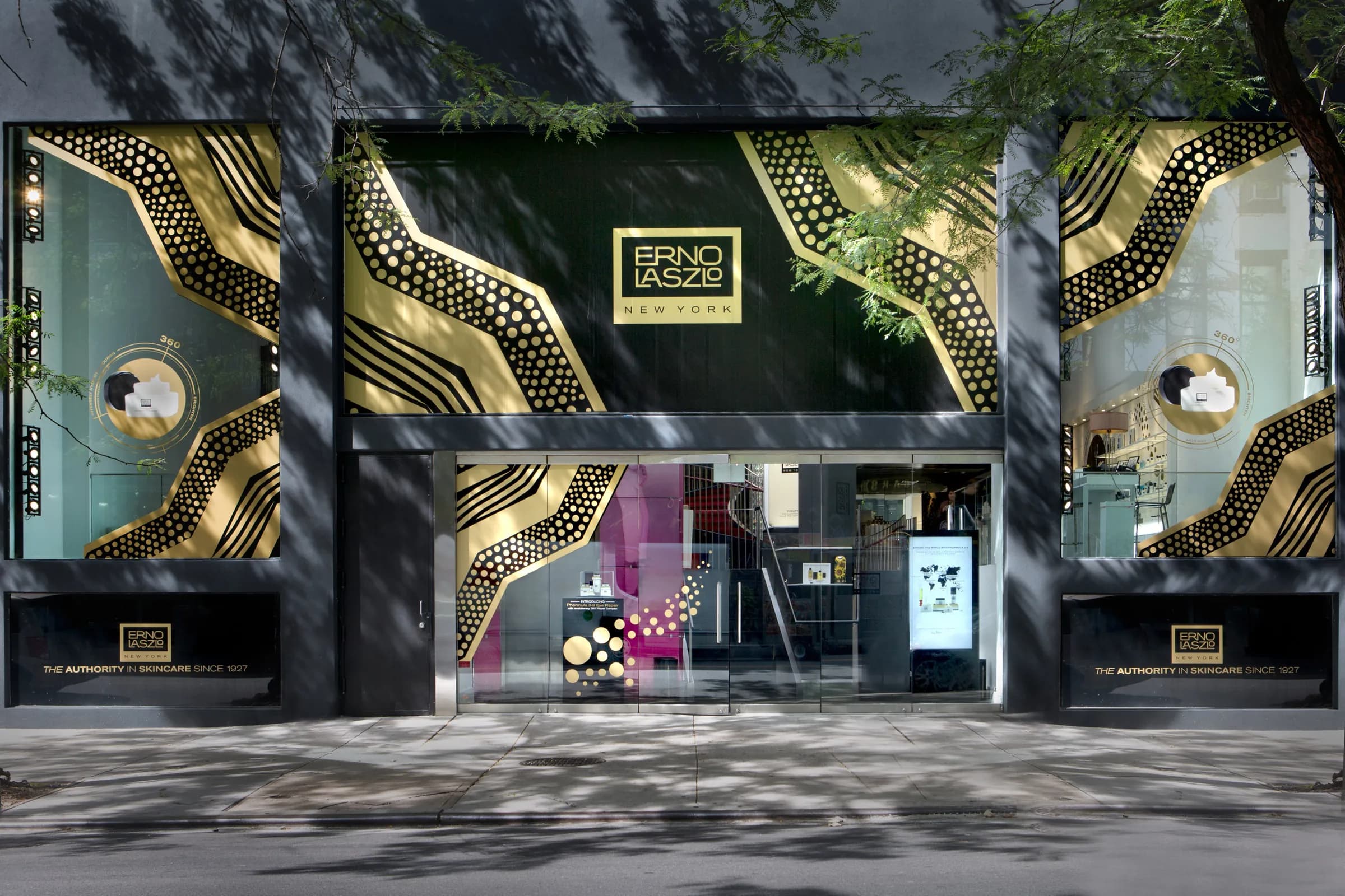 Erno Laszlo storefront wrapped in bold black and gold graphics, with the brand's logo panel above the entrance