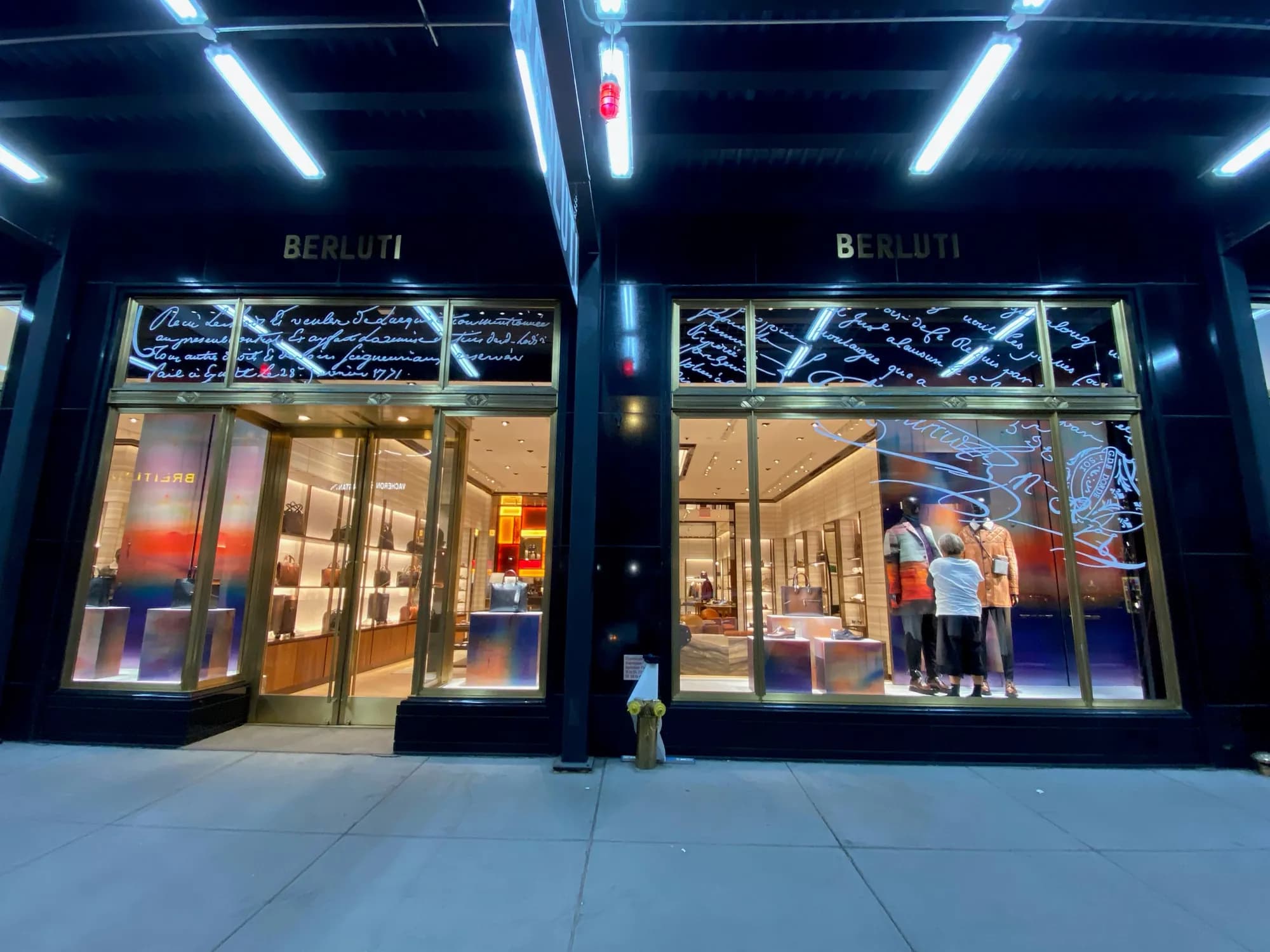 Wide night view of the Berluti New York storefront with gradient window displays