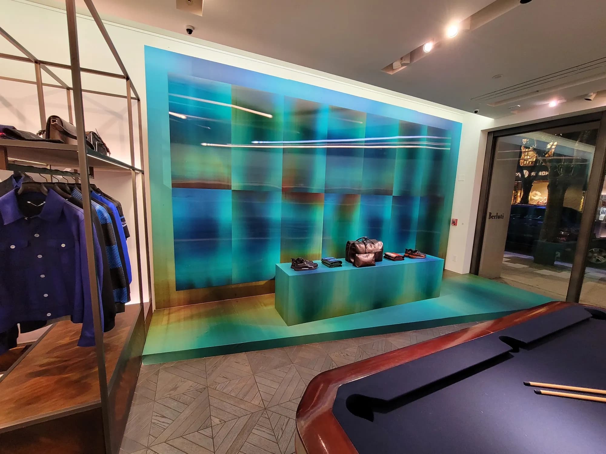 Teal gradient backdrop and plinth installation inside the Berluti Miami Design District store