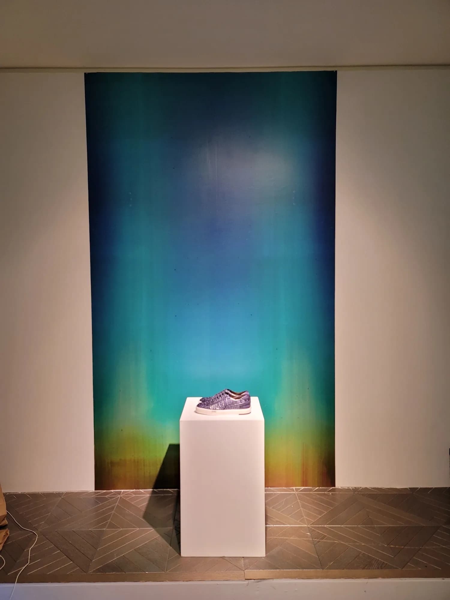 Gradient panel and white pedestal feature wall in the Berluti boutique