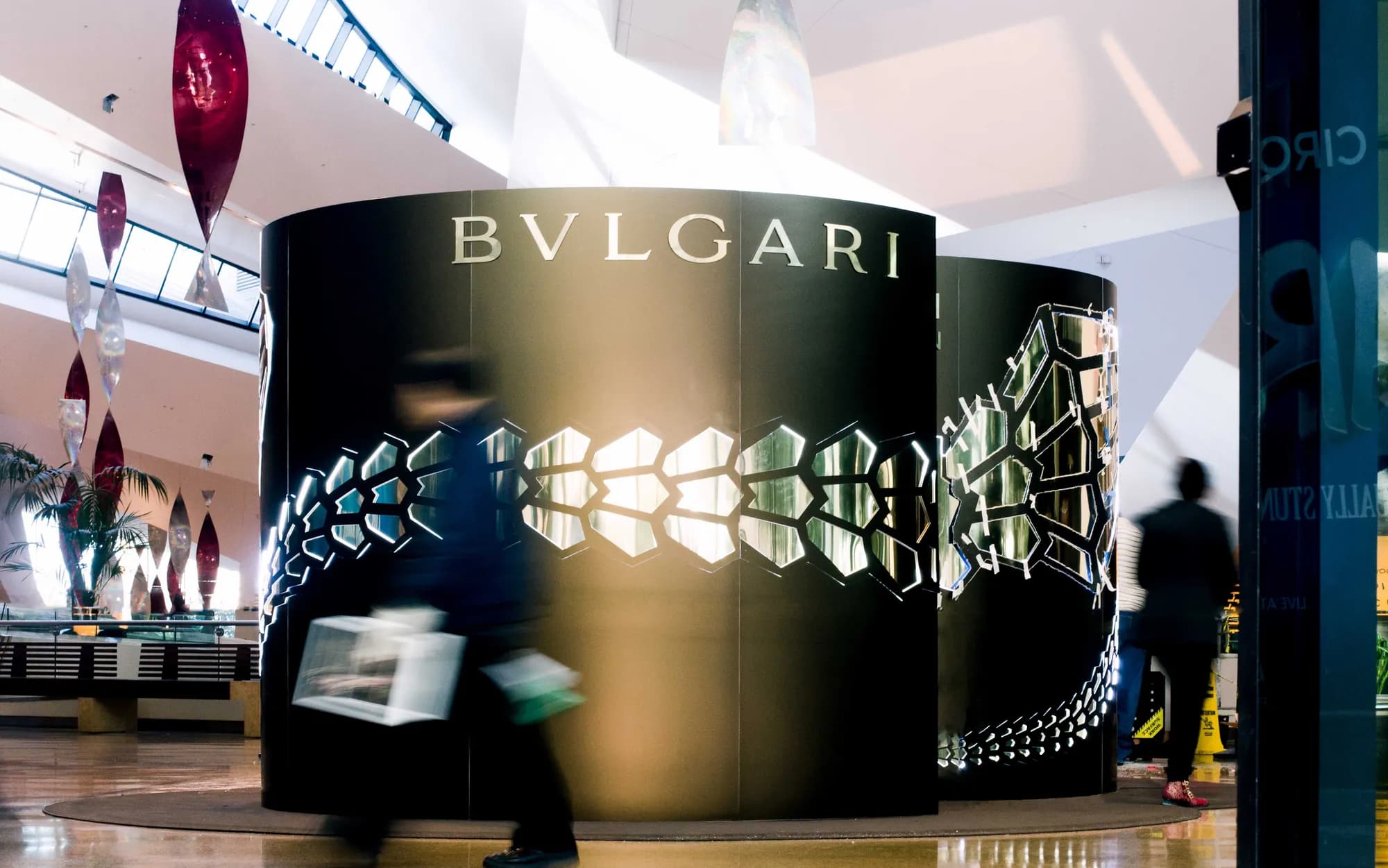 Serpenti pop-up pavilion with backlit mirrored scale band inside a shopping center