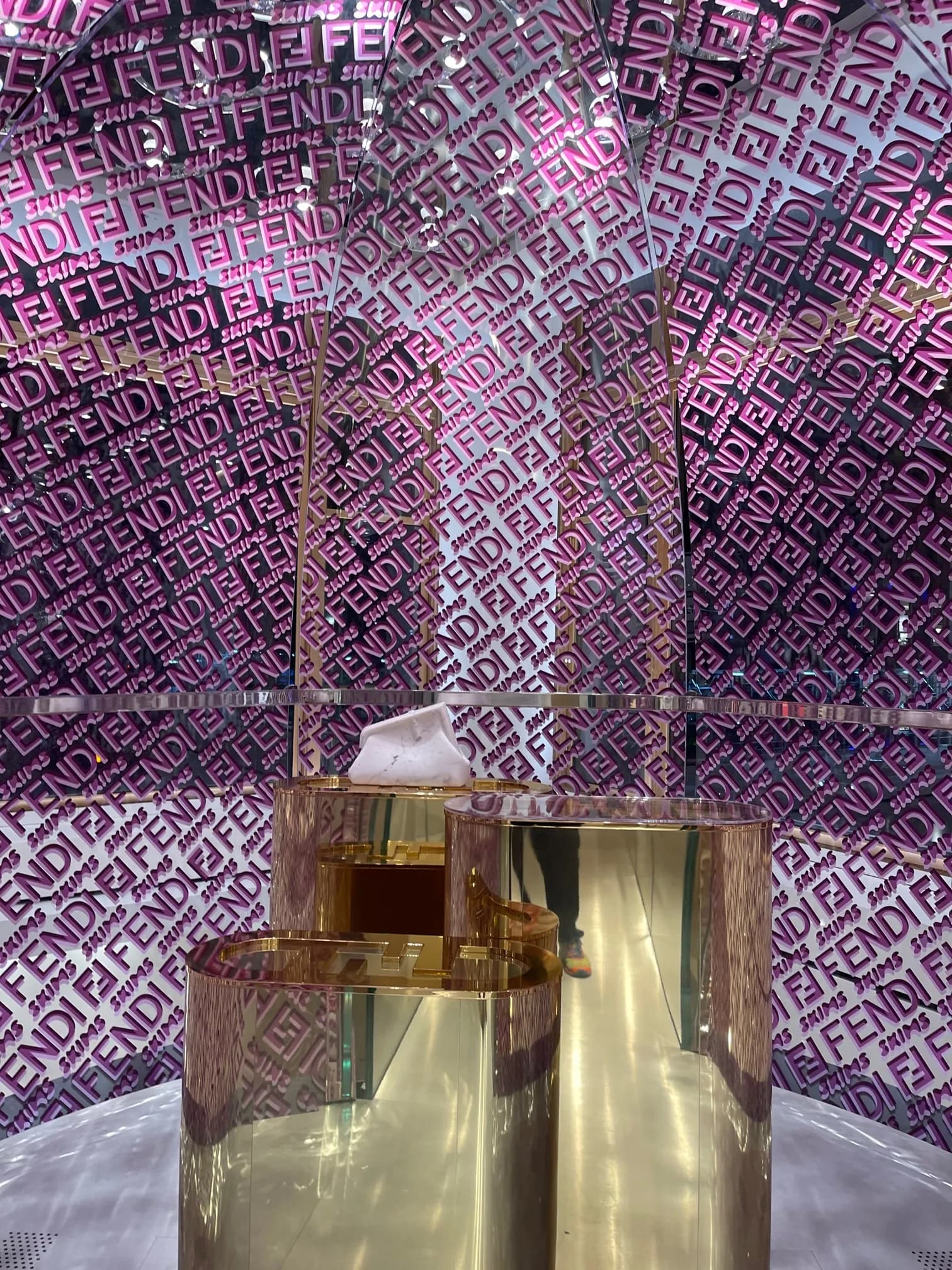 Inside the Fendi x Skims bubble on 57th Street: FENDI and SKIMS lettering on every wall around a mirrored gold display