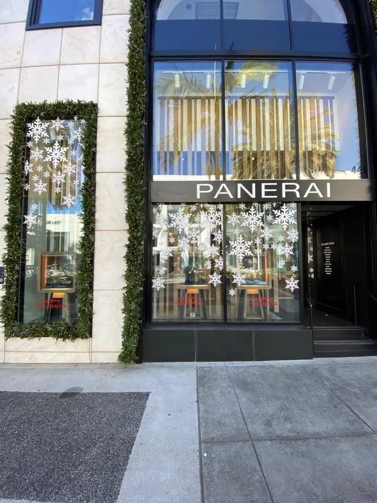 Panerai Beverly Hills storefront with snowflake window graphics and a greenery frame