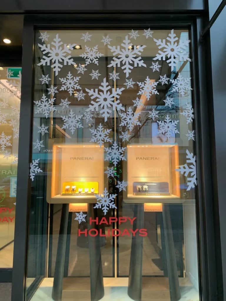Panerai Vancouver window at night with snowflakes and a red Happy Holidays message