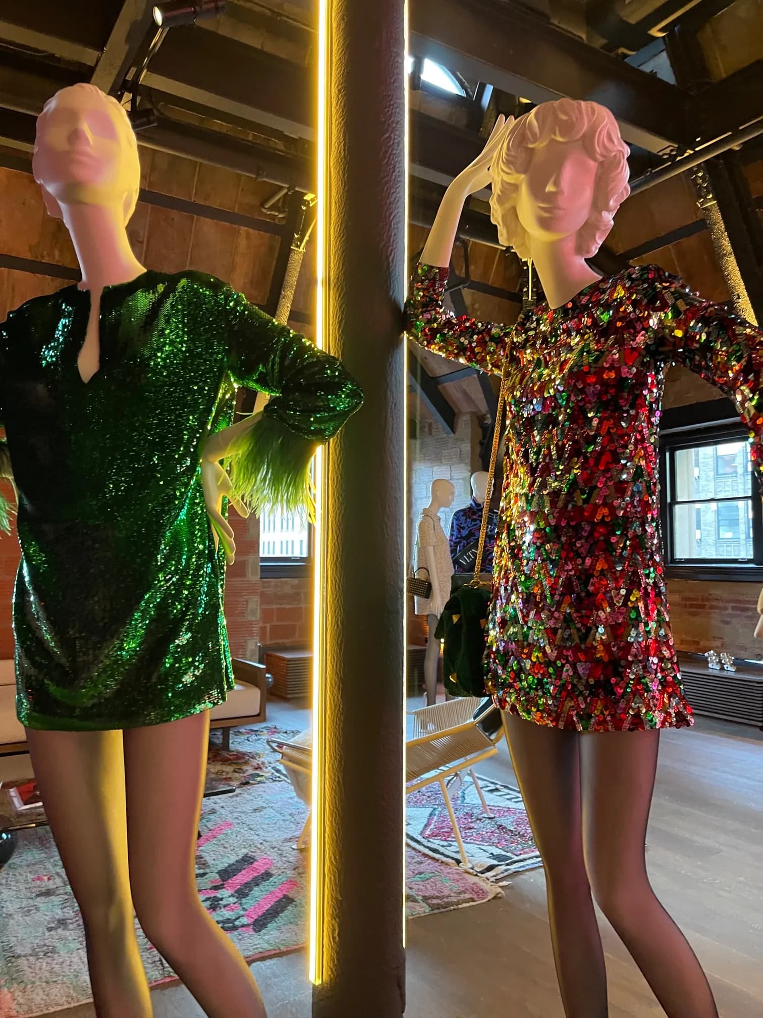 Two mannequins in sequined Valentino Party Collection dresses beside neon light poles