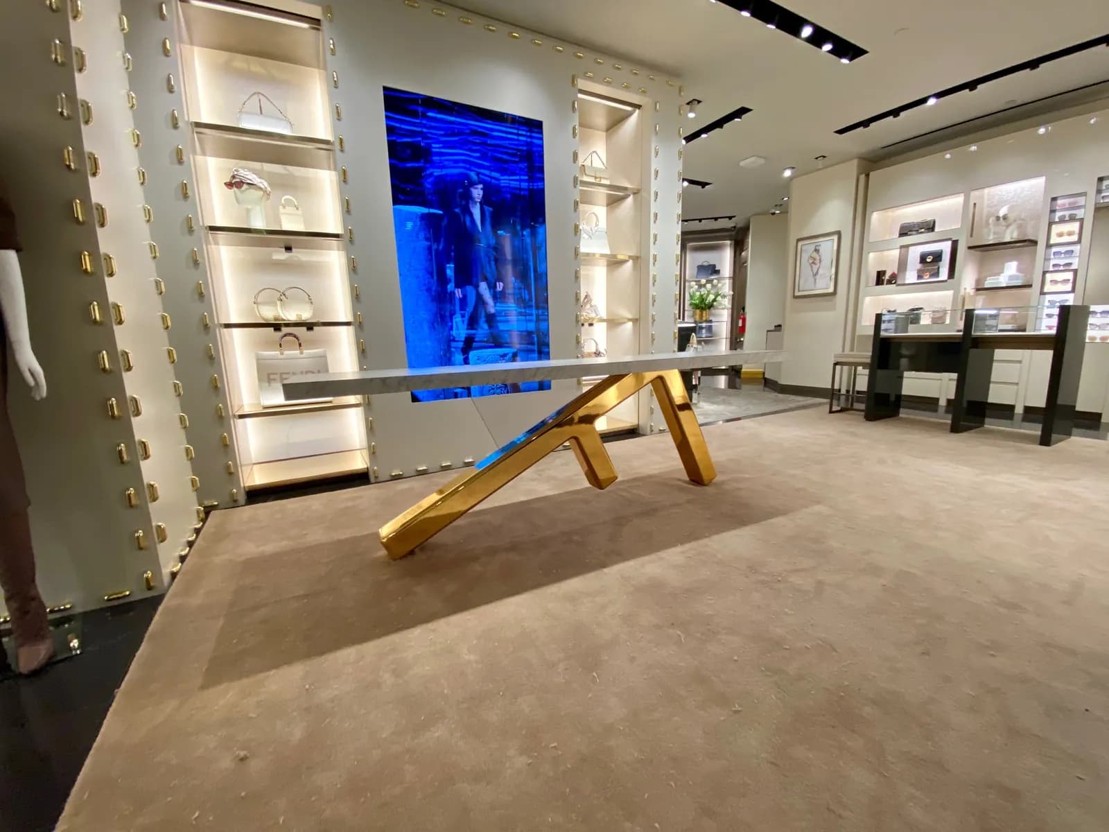 Custom Fendi table with sculptural gold-chromed F-shaped legs in a boutique