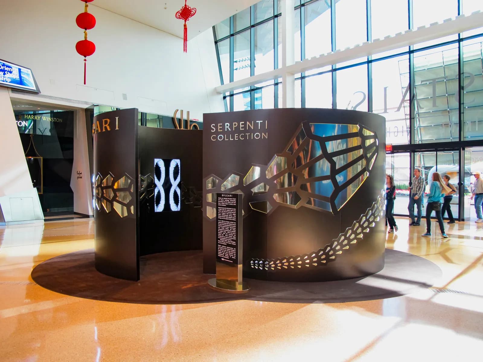 Bulgari Serpenti Collection pop-up pavilion with curved mirrored panels in a shopping center atrium